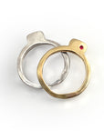 Two Square Splice Band rings, one in silver with a square bevel and one in gold with a red gemstone, showcasing unique handcrafted design for stacking or individual wear