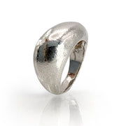 Handcrafted sterling silver statement ring with organic, hammered texture and curved dome design, reflecting light for a bold, contemporary look