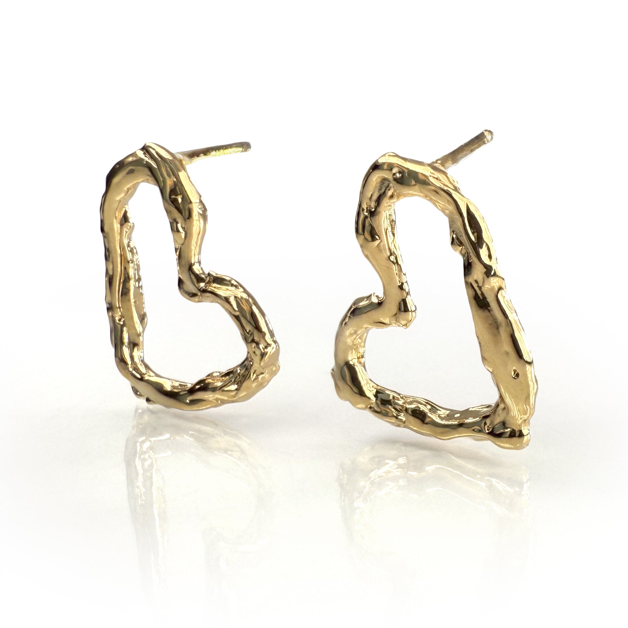 Textured gold heart-shaped stud earrings with unique hand-sculpted design, featuring irregular surface patterns and delicate contours, reflecting light for a shimmering effect, perfect for expressing love and style